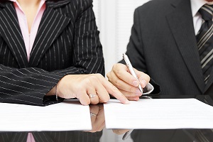 Real Estate Law attorneys sitting down and signing contracts